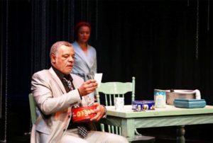 Die Dans van die Watermeid review - Kim (Rehane Abrahams) waits on the Dominee (Abduraghmaan Adams) in her grandmother's kitchen.