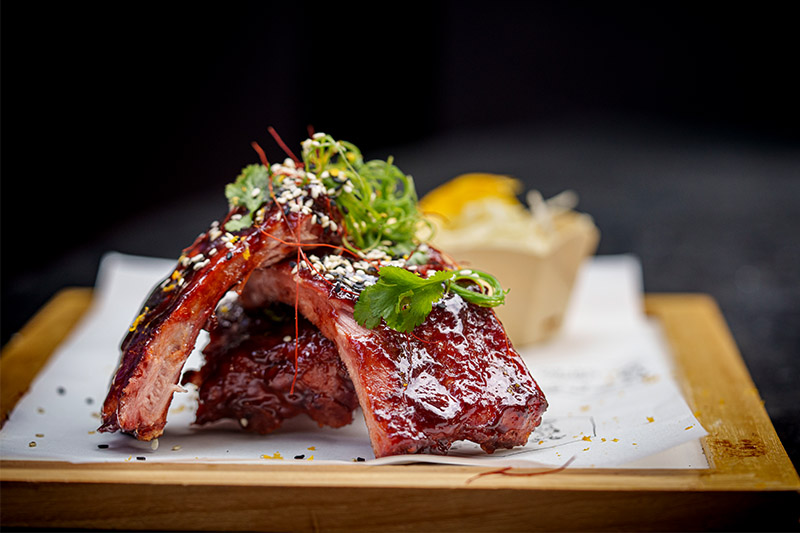 Sticky baby pork ribs with a gochujang glaze, celeriac, and apple and orange remoulade on The Test Kitchen Fledgelings Winter Street Food Fiesta menu.